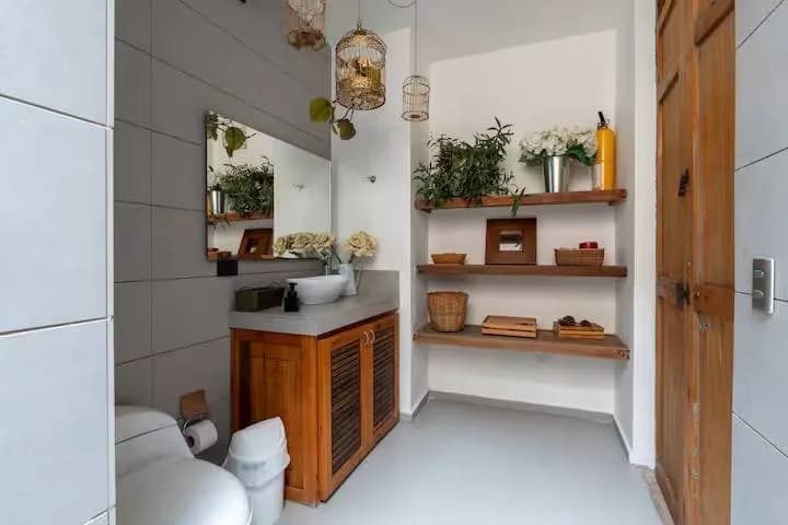 Baño con repisas de madera y plantas