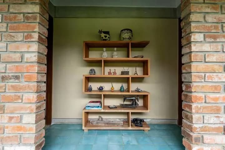 Repisa de madera con objetos decorativos en un nicho de ladrillo