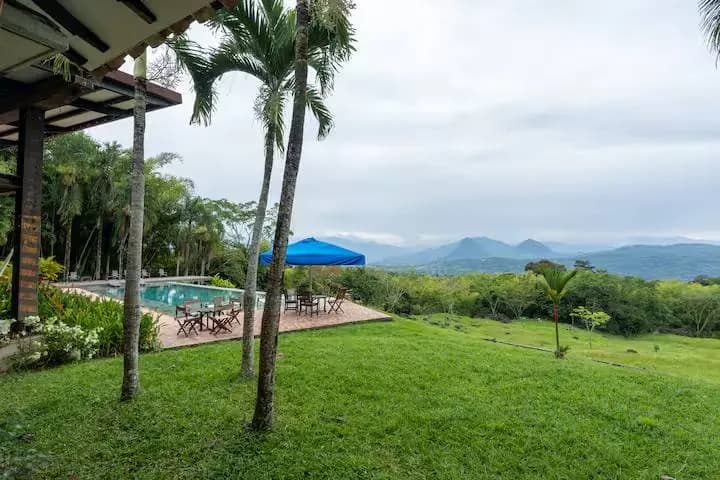 Piscina de Finca Cuatro Gatos con palmeras y vista a las montañas